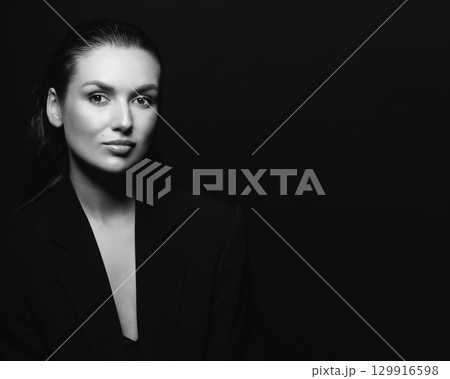 Beautiful woman with dark suit and wet hair studio portrait 129916598