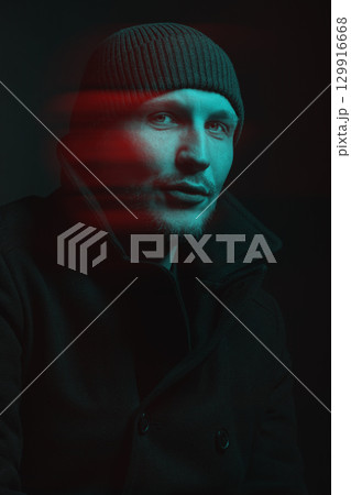 Serious man with black winter coat and winter hat studio portrait in glitch and RGB color split effect style 129916668