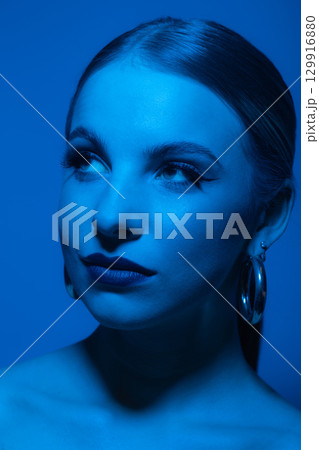 Abstract beautiful woman studio portrait with classic hairstyle and round golden earrings Abstract beautiful woman studio portrait with classic hairstyle and round golden earrings 129916880