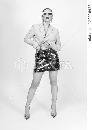 Woman black and white studio portrait with jacket and mini skirt Woman black and white studio portrait with jacket and mini skirt 129916928