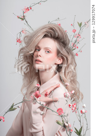 Beautiful woman with big wavy hair and flowers studio portrait Beautiful woman with big wavy hair and flowers studio portrait 129917074
