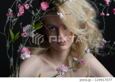 Beautiful woman with big wavy hair and flowers studio portrait Beautiful woman with big wavy hair and flowers studio portrait 129917077