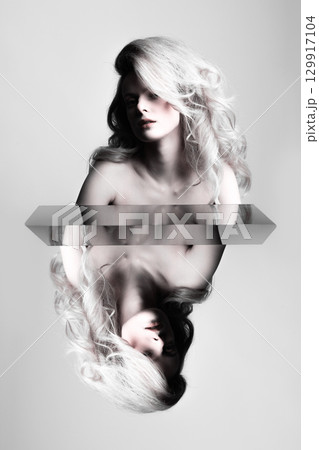 Beautiful woman with big wavy hair studio portrait with reflection effect 129917104