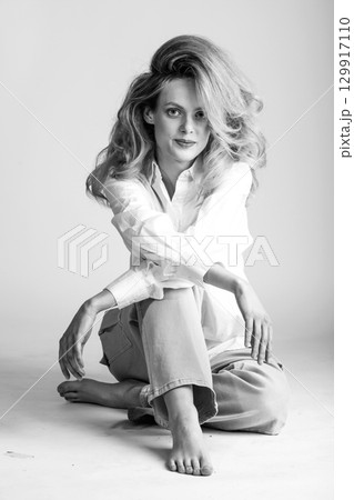 Beautiful woman with big wavy hair black and white studio portrait 129917110