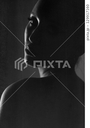 Beautiful woman dark silhouette studio portrait on gray background in grunge effect style Beautiful woman dark silhouette studio portrait on gray background in grunge effect style 129917160