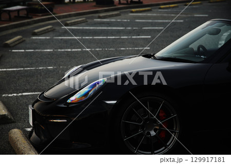 駐車場に佇む黒いオープンカー 129917181