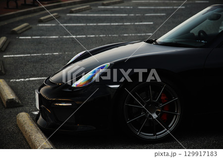 駐車場に佇む黒いオープンカー 129917183