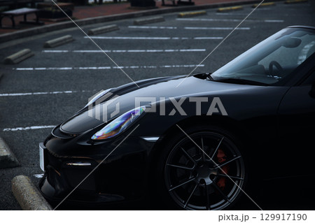 駐車場に佇む黒いオープンカー 129917190