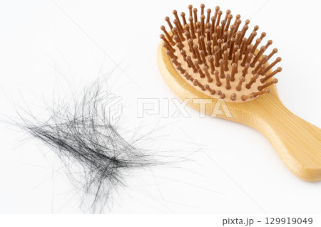 白背景に竹製のヘアブラシと抜けた髪の毛 129919049
