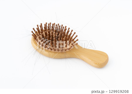 白背景に髪の毛のついた竹製のヘアブラシ 129919208