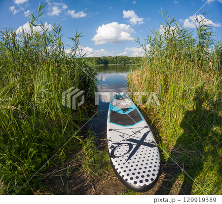 Stand-Up Paddleboard by a Tranquil Lake 129919389