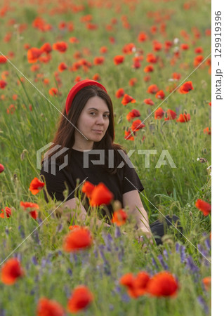 Young Woman in Poppy Field with Red Hat Young Woman in Poppy Field with Red Hat 129919396