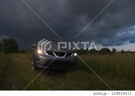 SUV in a Field Under Dramatic Skies SUV in a Field Under Dramatic Skies 129919411