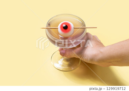 Halloween cocktail garnished with candy eye Halloween cocktail garnished with candy eye 129919712