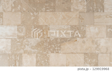 Antique ancient stone wall masonry texture background. Old wall made of beige stone blocks  129919968