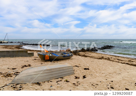 Blue sky stretches above calm sea, boats resting near sandy beach. Blue sky stretches above calm sea, boats resting near sandy beach. 129920087