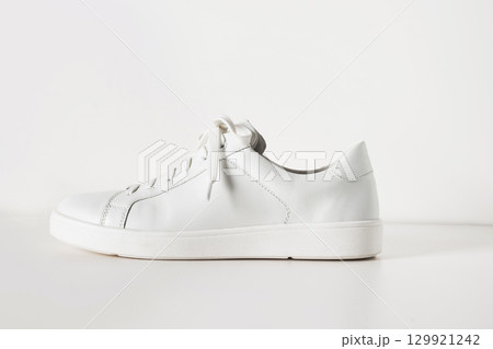 New white sneaker isolated on white background. Creative shoes modern style, fashion concept. Summer womens footwear. Copy space. New white sneaker isolated on white background. Creative shoes modern style, fashion concept. Summer womens footwear. Copy space. 129921242