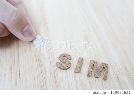 SIMカードとSIMの文字。コピースペースの写真素材。 SIMカードとSIMの文字。コピースペースの写真素材。 129921621