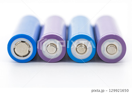 Closeup rechargeable batteries purple blue cylindrical shape metal terminal energy storage isolated on white background clean modern technology concept 129921650