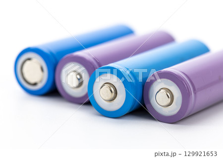 Colorful rechargeable batteries with blue and purple casing arranged in row on white background, showing metallic terminals and clean design, representing energy and technology Colorful rechargeable batteries with blue and purple casing arranged in row on white background, showing metallic terminals and clean design, representing energy and technology 129921653