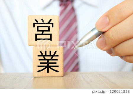 ビジネスマンと木製ブロックに営業の文字が並ぶ構図 ビジネスマンと木製ブロックに営業の文字が並ぶ構図 129921838
