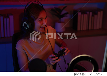 Joyful Gamer Celebrating Victory with Headset and Controller 129922426