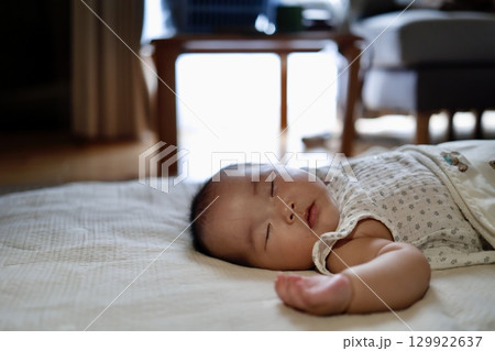 日差しの差し込む窓辺で昼寝する生後5ヶ月の赤ちゃん 129922637