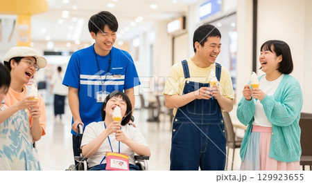 ショッピングセンターで笑顔で過ごす車いすの障がい者と支援員の男性写真 129923655