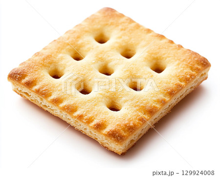 A close-up shot of a small pile of square creme crackers stacked against a plain white background. The crackers are golden-brown with small holes on their surface. A close-up shot of a small pile of square creme crackers stacked against a plain white background. The crackers are golden-brown with small holes on their surface. 129924008