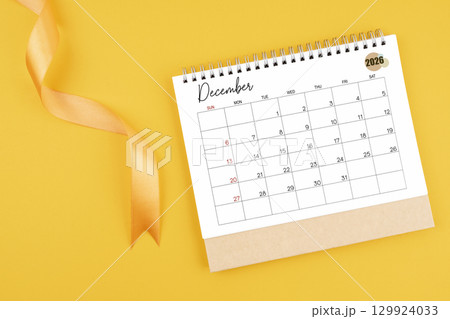 December 2026 desk calendar with yellow ribbon on yellow color background, Flat lay. 129924033