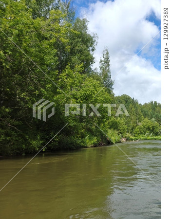 Scenic River Landscape with Lush Greenery and Clear Sky, Perfect for Outdoor Adventures 129927389