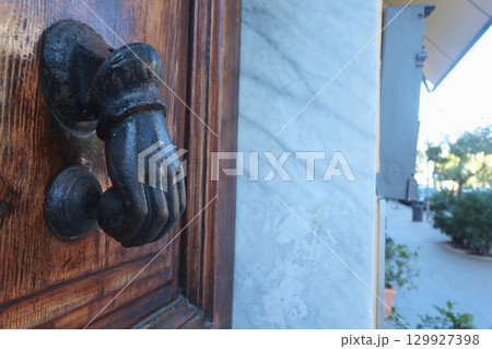 Door knocker on wooden door in traditional house. Vintage element on building. Door knocker on wooden door in traditional house. Vintage element on building. 129927398