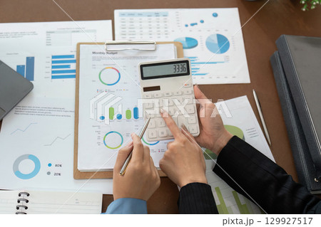 Financial advisor calculating monthly budget with client Financial advisor calculating monthly budget with client 129927517