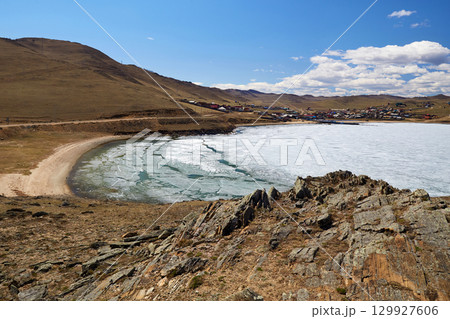 Spring landscape of Lake Baikal. Small sea bay near the village of Sakhyurt. The time of ice melting on the lake. Spring landscape of Lake Baikal. Small sea bay near the village of Sakhyurt. The time of ice melting on the lake. 129927606