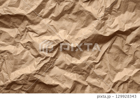 Recycle brown paper crumpled texture. Wrapping craft old paper surface for background. Crinkled Kraft Sheet. Textured Cardboard Backdrop. Full frame. Copy space. Concept of using recycled materials. 129928343