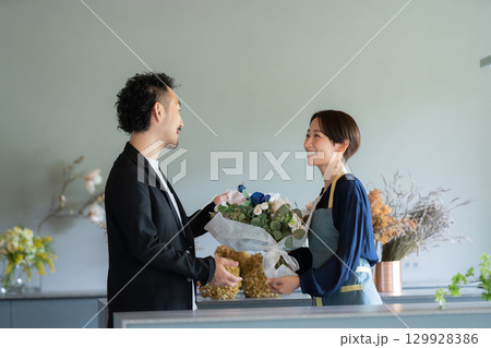 フラワーショップで花を買う男性客 129928386