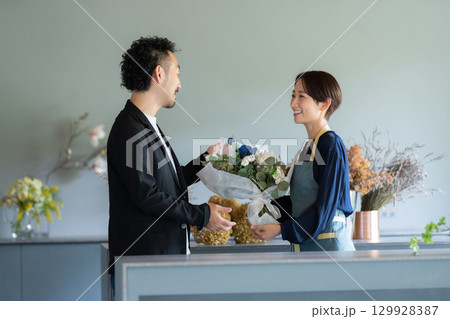 フラワーショップで花を買う男性客 129928387