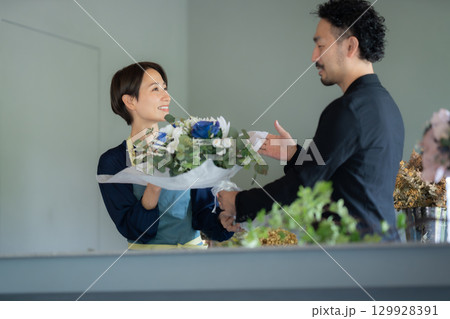 フラワーショップで花を買う男性客 129928391