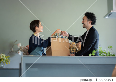 フラワーショップで花を買う男性客 129928394