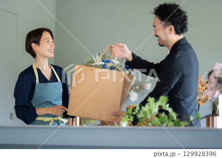 フラワーショップで花を買う男性客 129928396
