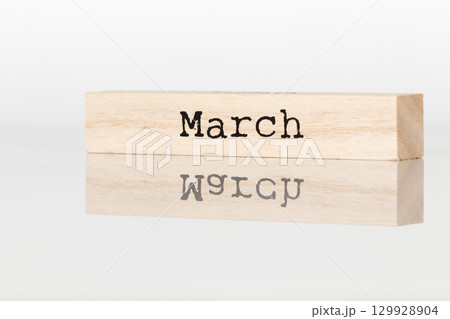 a wooden cube with an inscription in March on a white background a wooden cube with an inscription in March on a white background 129928904
