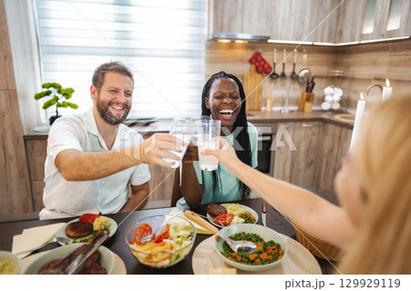 Friends enjoy laughter and joy at dinner together 129929119