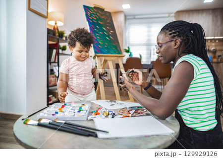 Creative bonding: A mother and child enjoy painting together Creative bonding: A mother and child enjoy painting together 129929126