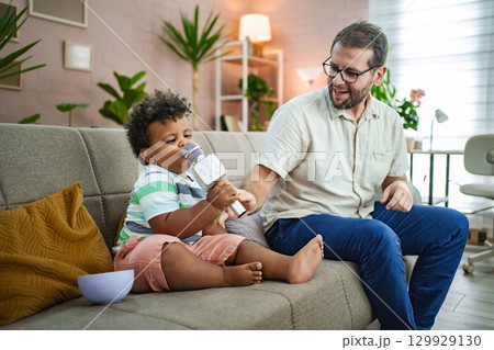 Child enjoys singing with parent in cozy living room Child enjoys singing with parent in cozy living room 129929130