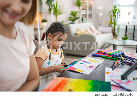 Mother and daughter engage in creative arts and crafts at home during a sunny afternoon Mother and daughter engage in creative arts and crafts at home during a sunny afternoon 129929146