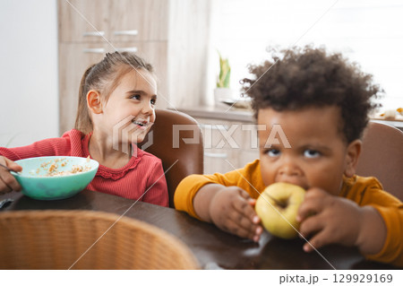 Multiracial family enjoying breakfast on a sunny morning 129929169