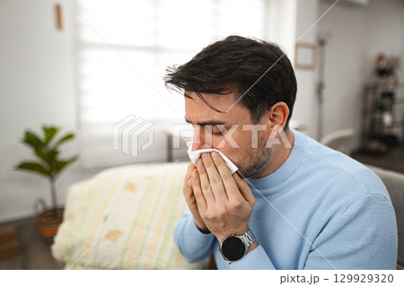 Man Blowing His Nose With a Napkin 129929320