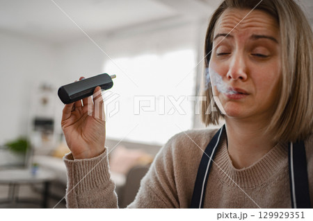 Woman enjoying a moment of relaxation with steam in her home 129929351