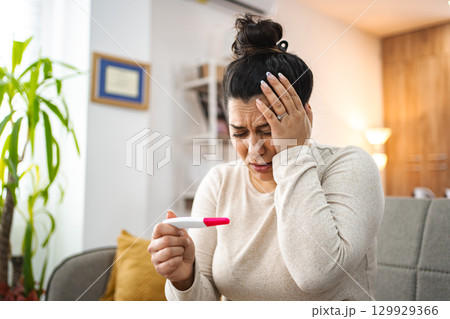 Woman feeling worried after doing a pregnancy test 129929366