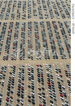 Parked new cars at the automotive plant factory parking lot ready for sale. Development of American industry concept Parked new cars at the automotive plant factory parking lot ready for sale. Development of American industry concept 129929762